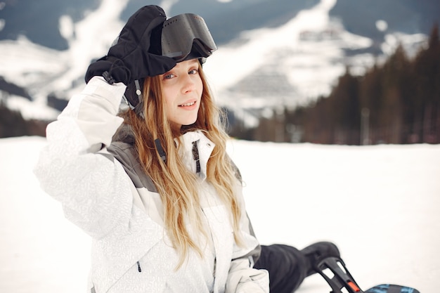 Free Photo woman in snowboard suit. sportswoman on a mountain with a snowboard in the hands on the horizon. concept on sports