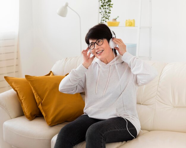 Woman on sofa at home listening to music