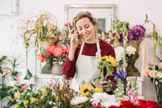 Woman speaking on smartphone in floral shop