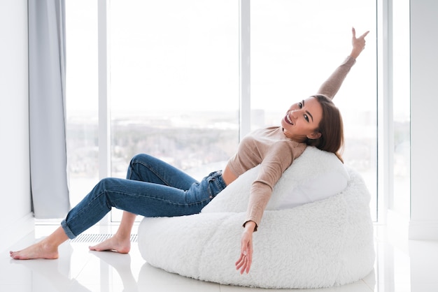 Free Photo woman spending time indoors on a bean bag