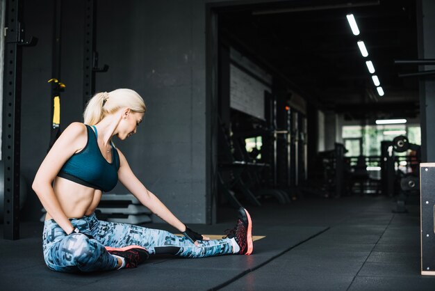 Woman in sports bra and leggings stretching