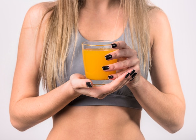 Free photo woman in sportswear with glass of juice