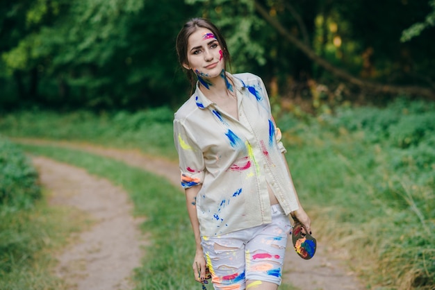 Free Photo woman stained by paint walking on a dirt road