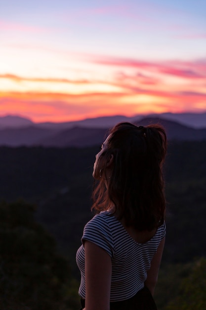 Free Photo woman standing in front on a beautiful background at dawn