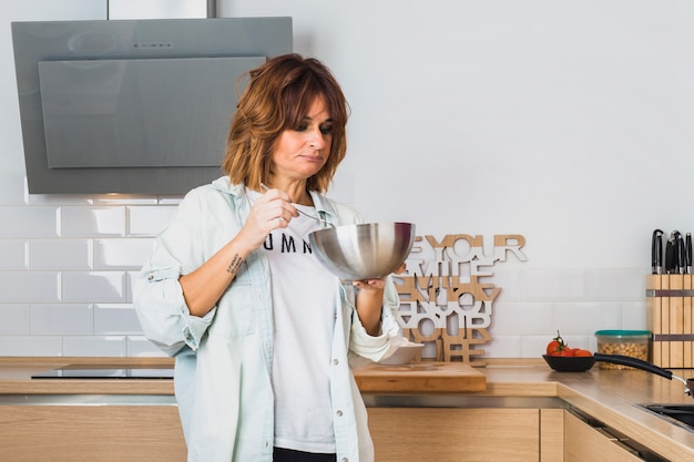 Woman standing in kitchen and eating