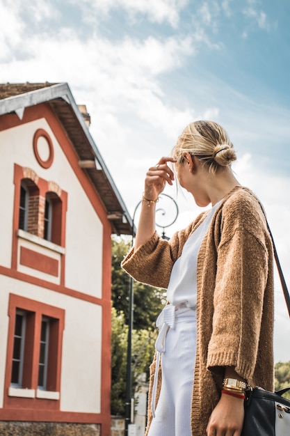 Woman standing outside house during sunny day