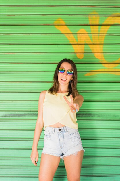 Woman standing and showing peace gesture