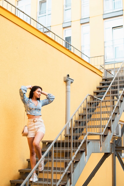 Free photo woman standing on stairs and looking away