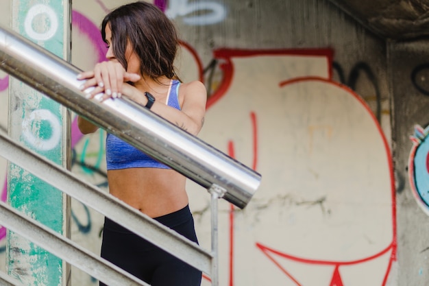 Free Photo woman standing on stairs touching parapet