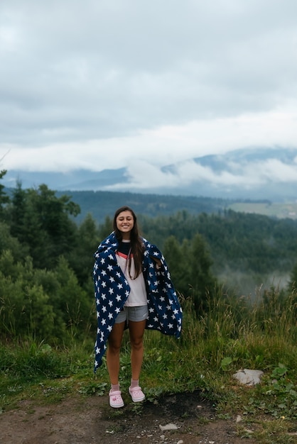 Woman standing on top of a hill against the background of a valley