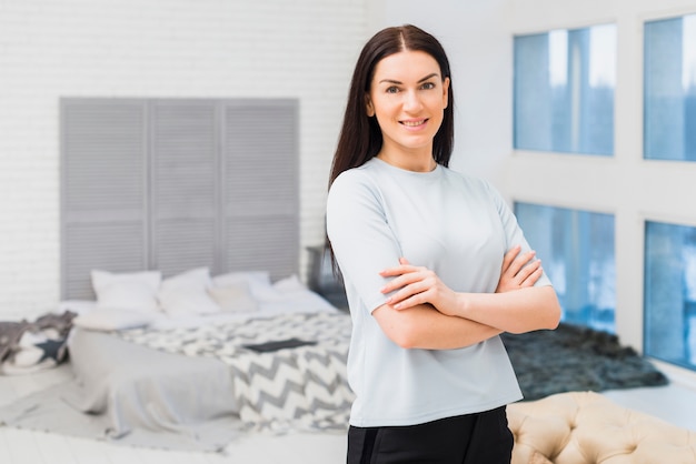 Free photo woman standing with crossed arms at home