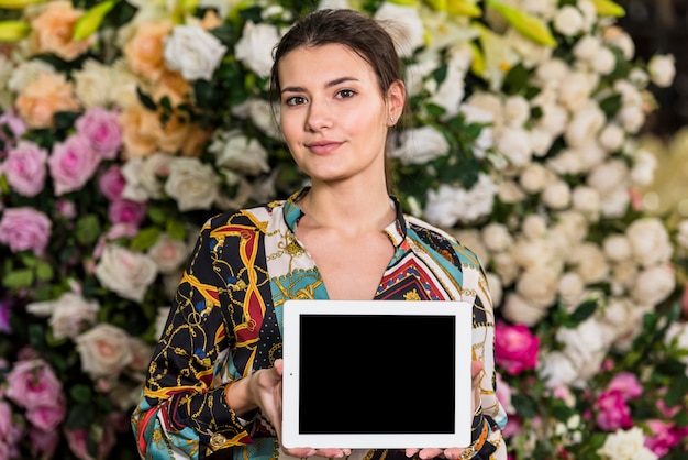 Free photo woman standing with tablet in green house