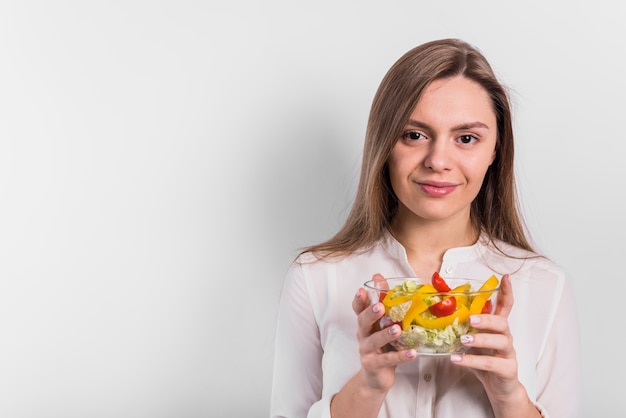 Woman standing with vegetable salad in small bowl