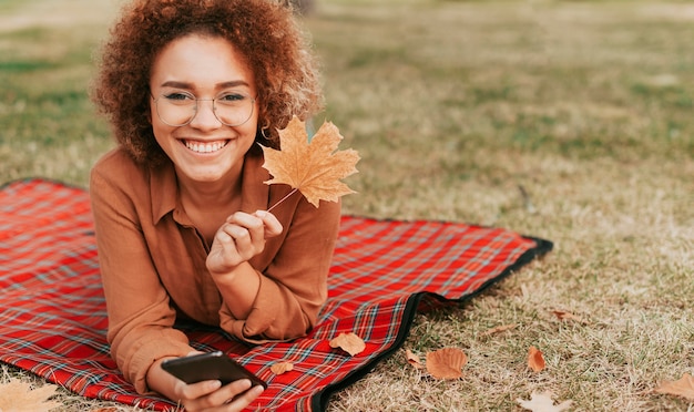 Woman staying on a blanket with copy space in autumn