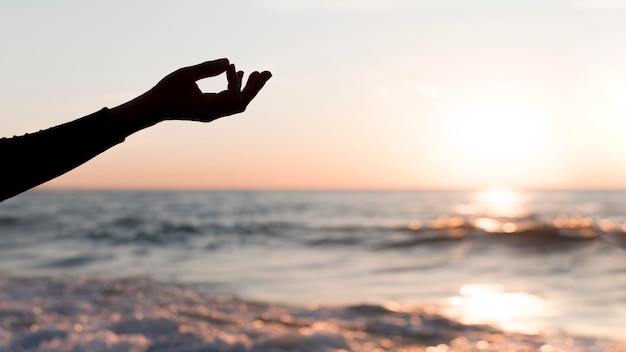 Woman staying with her arm next to her at sunset with copy space