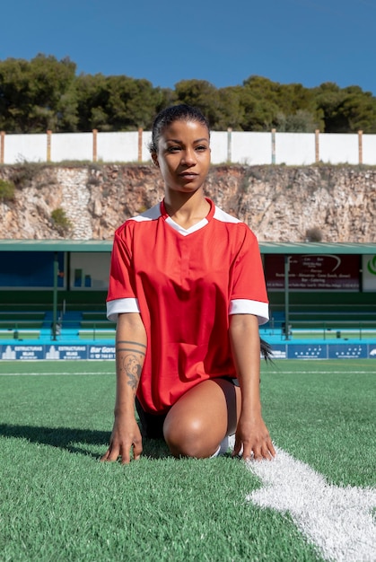 Woman stretching leg on field