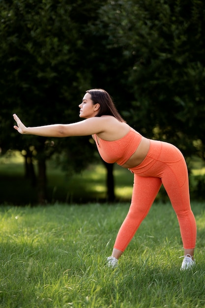 Free photo woman stretching in nature full shot