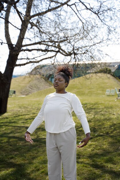 Woman stretching outdoors medium shot