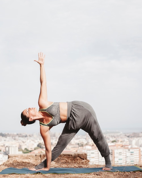 Woman stretching to the side with city in background