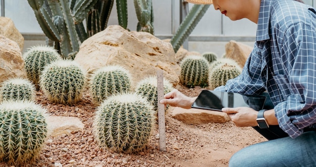 Free photo woman studying different plants with a tablet