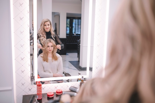 Free photo woman styling girl in hairdresser parlor