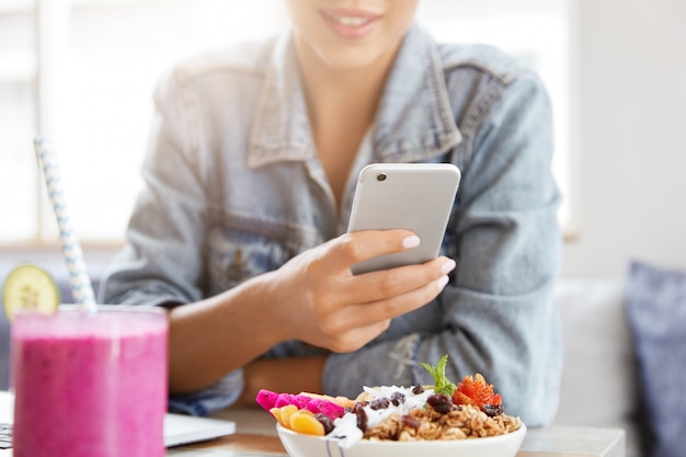 Woman in stylish denim jacket in coffee shop