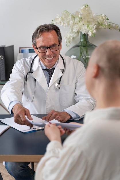 Woman suffering of breast cancer talking with her doctor