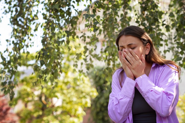 Woman suffering from allergies outside