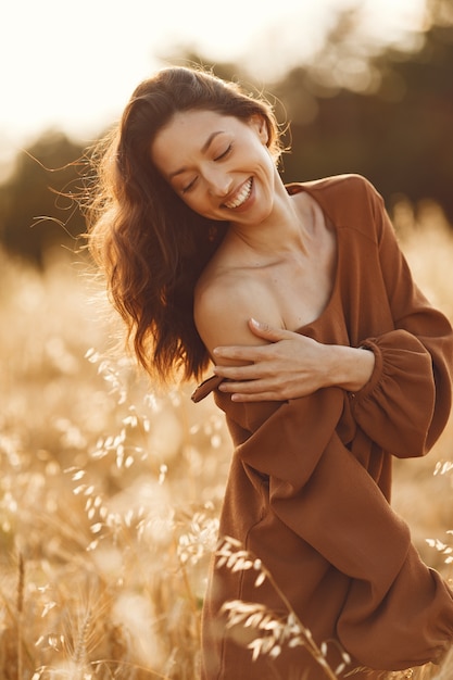 Free photo woman in a summer field. brunette in a brown sweater.