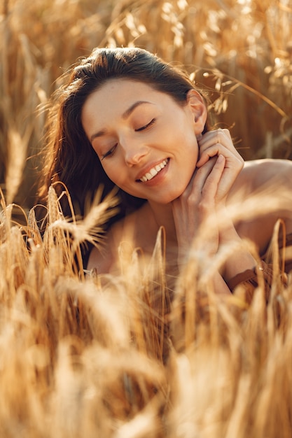 Woman in a summer field. Brunette in a brown sweater. 