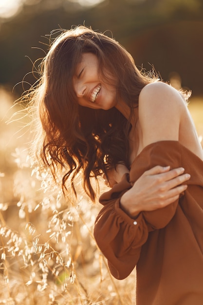 Free Photo woman in a summer field. brunette in a brown sweater. 