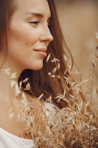 Woman in a summer field. Brunette in a white dress. 