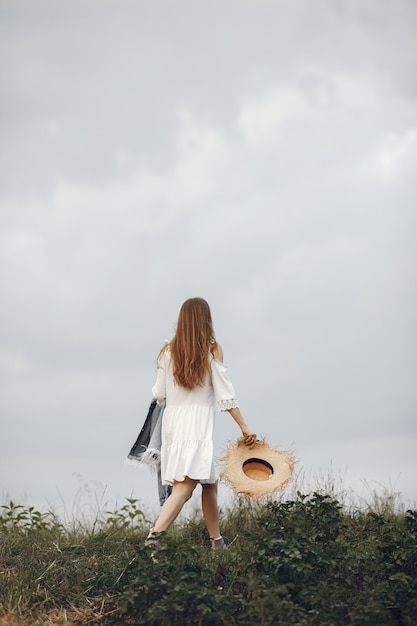 Free Photo woman in a summer field. lady in a white dress. 