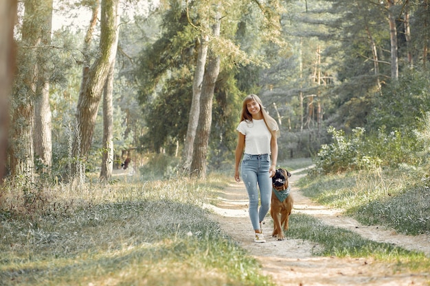 Free photo woman in a summer forest playing with dog