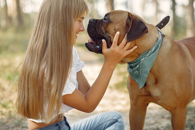 Free photo woman in a summer forest playing with dog