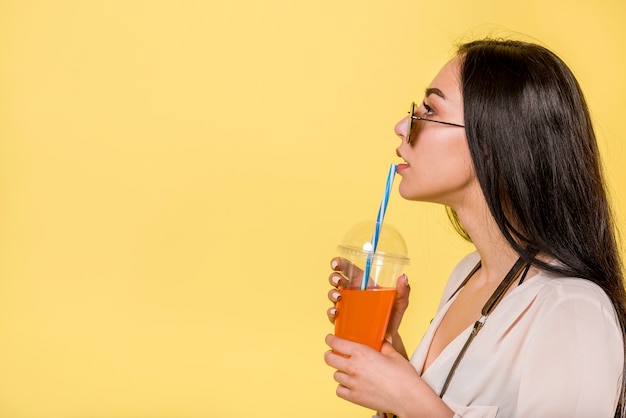 Free photo woman in sunglasses drinking juice