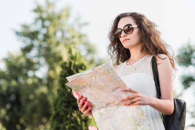 Woman in sunglasses with map