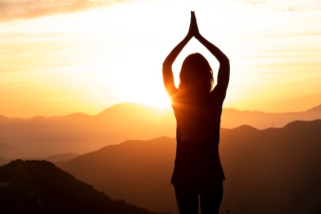 Woman in the sunset doing yoga