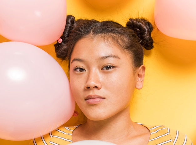 Woman surrounded by balloons looking at camera