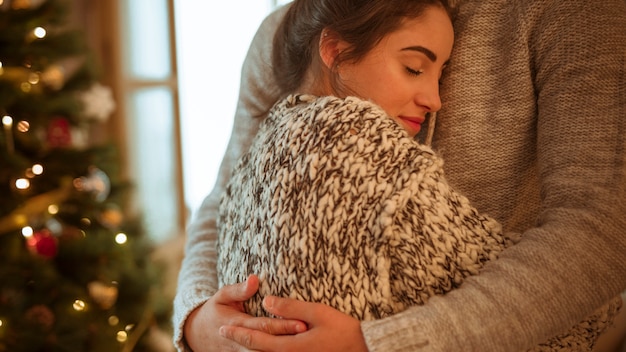 Free photo woman in sweater hugging man