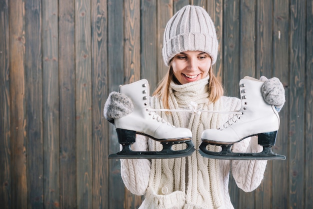 Free photo woman in sweater looking at skates