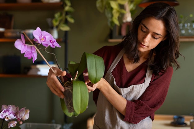 Free Photo woman taking care of exotic orchid