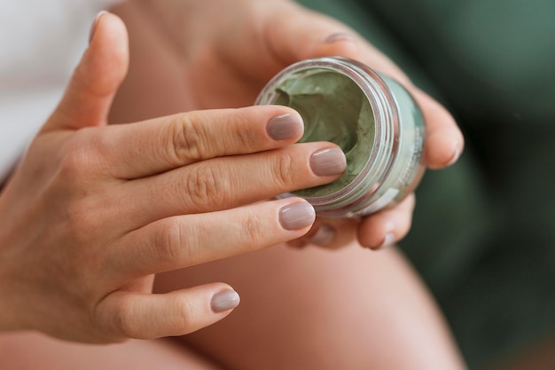 Woman taking facial mask from container