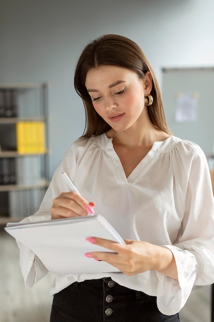 Woman taking notes on her notebook at work