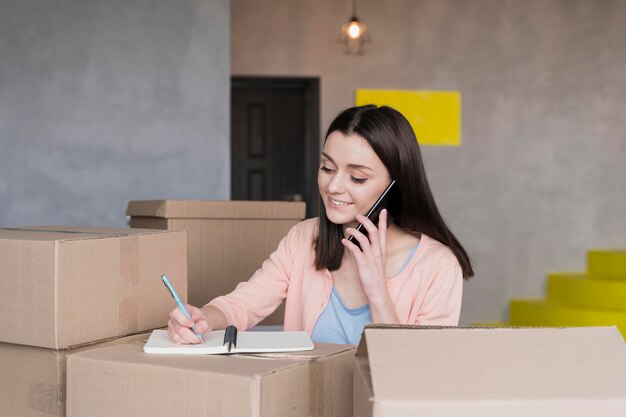 Woman taking orders from home surrounded by boxes