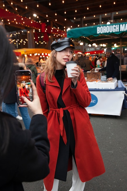 Free photo woman taking photo of a female influencer at the market