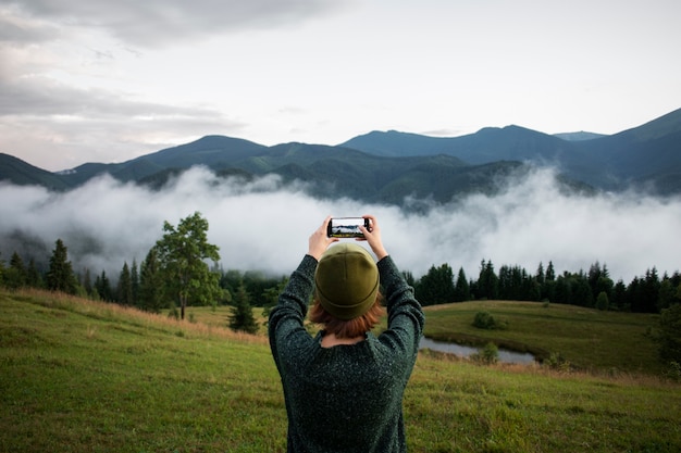 Free photo woman taking a photo of the rural surroundings