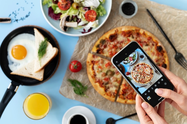 Free photo woman taking photo of sliced pizza