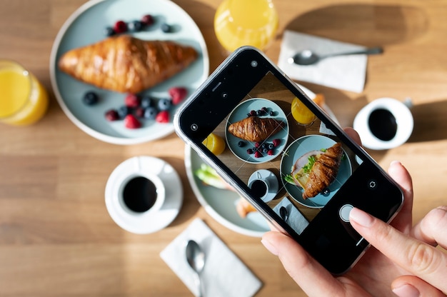 Free photo woman taking photo of two croissants