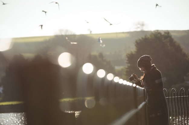 Woman taking photos on digital camera in park